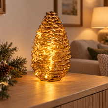 Amber glass pinecone LED light illuminated on an oak sideboard in a cosy living room